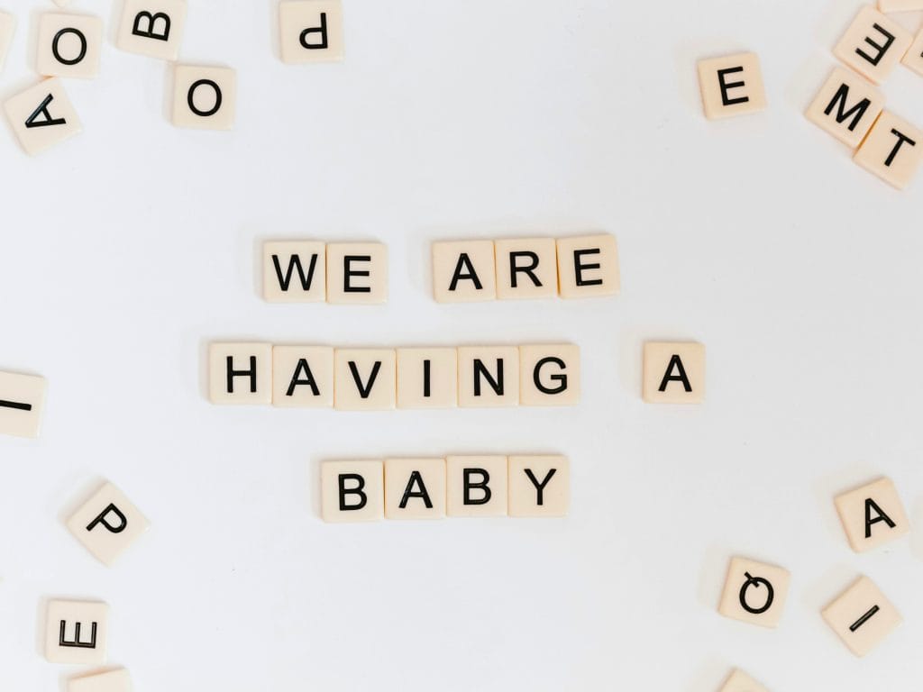 Scrabble Letter Tiles spelling out we are having a baby.