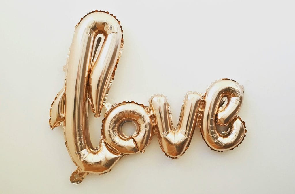 Gold letter balloons spelling love.
